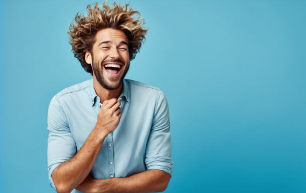 The person in the image is wearing a light blue button-up shirt with the sleeves rolled up. They have curly, voluminous hair and are posing with one hand touching their chin, suggesting a thoughtful or contemplative expression. The background is a solid light blue color, creating a clean and simple backdrop.