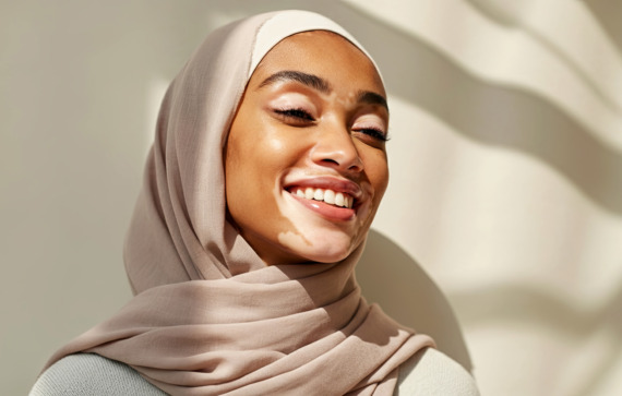 Portrait of a person wearing a soft beige hijab with gentle natural light and shadows creating a serene and graceful atmosphere.