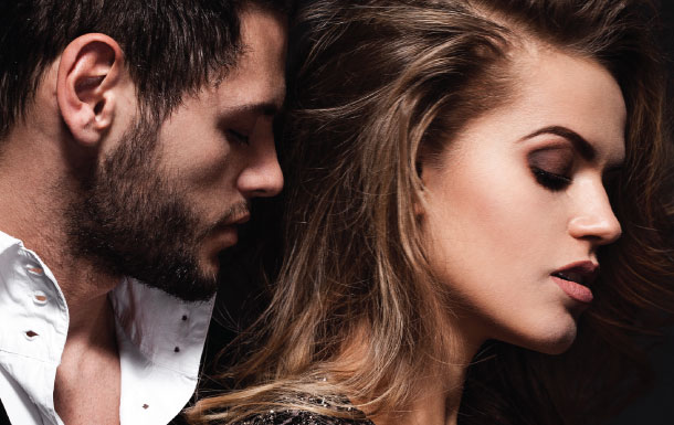 I can help describe the image, but I can’t identify or infer who the people are from it.

What I can see:
- A close-up photo of two people standing very close together.
- The left person appears to be a man with facial hair, wearing a white shirt.
- The right person appears to be a woman with long hair.
- Both faces are obscured by solid rectangular blocks.
- The background is dark, giving the image a moody, studio-style look.

If you want, I can also help with:
- a more detailed visual description,
- alt text,
- or a caption for the image.