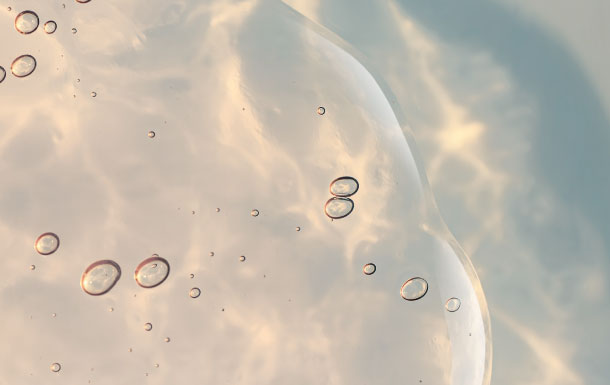 Abstract close-up of translucent bubbles floating in pale, softly lit liquid
